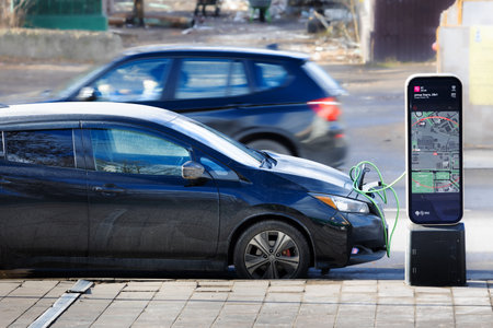 Moscow, Russia - 13 November, 2022: Charging an electric car on city street charging station. Eco car concept. Energy of Moscow is a public charging station for electric vehicleのeditorial素材