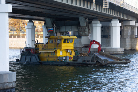 Trash skimmer boat cleaning the water surface of the Moscow river from garbage in Moscow, Russia. River cleaning boat collects garbage on water surface of river. Floating debris removal systemsの写真素材