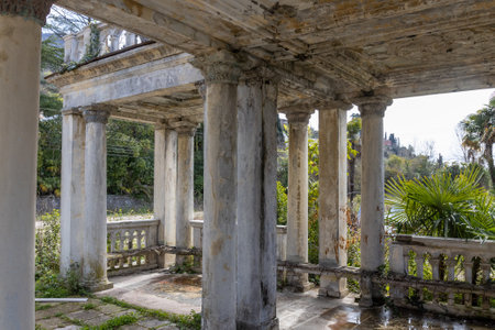 Fragment of decay marble colonnade of abandoned railway platform Gagrypsh overgrown with tropical greenery in Gagra, Abkhazia, Georgiaの写真素材
