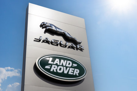 Krasnoyarsk, Russia - May 19, 2022: Jaguar and Land Rover brand logos on stella against blue sky background. car dealership centerのeditorial素材