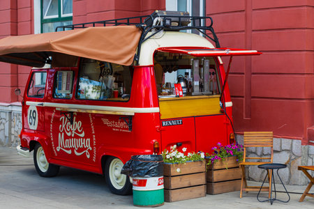 Krasnoyarsk, Russia - 30 June, 2023: Mobile coffee shop in red small cozy minibus on city street. street food truck.のeditorial素材