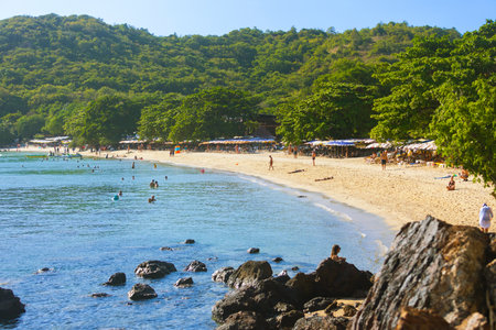 Pattaya, Thailand - December 21, 2023: People relaxing on the public beach and swimming in the sea on a tropical Koh Larn island, Thailandのeditorial素材