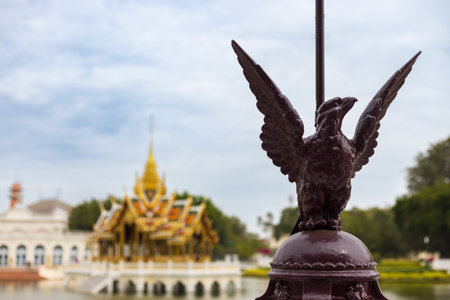 Close-up of Eagle statue on blurred background of the Aisawan Dhipaya-Asana Pavilion in Bang Pa-In Palace at Ayutthaya, Thailand. Travel background with copy spaceの写真素材