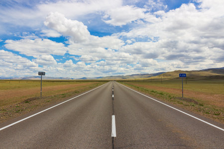 Empty Chuysky trakt road along steppe landscape against cloudy sky at Altai Republic, Russia. Summer prairie near border with Mongolia in Altai Republic, Russia. Russian route R256 or Chuya Highwayの写真素材