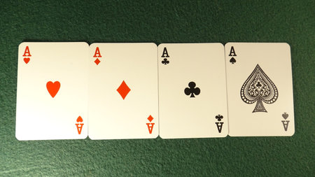 Four aces on green table, close up of playing cards.