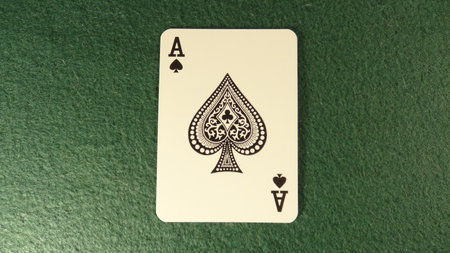 Ace of spades playing cards on green felt background, close up
