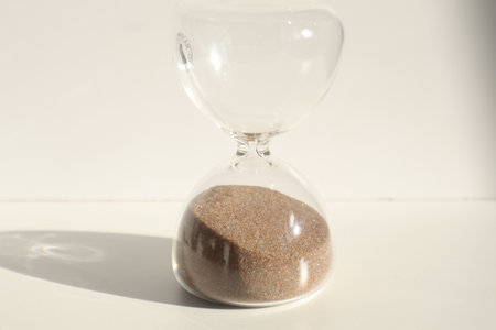 Hourglass with sand on white background. Concept of time passing.