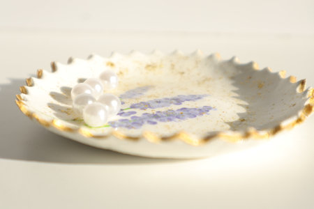 Ceramic plate with pearls on white background. Selective focus.の写真素材