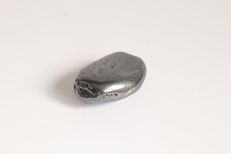 Hematite macro shooting of natural mineral rock specimen - tumbled jasper gemstone on white backgroundの写真素材
