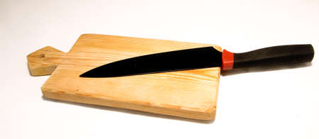 Empty chopping board with a sharp paring knife on white backgroundの写真素材