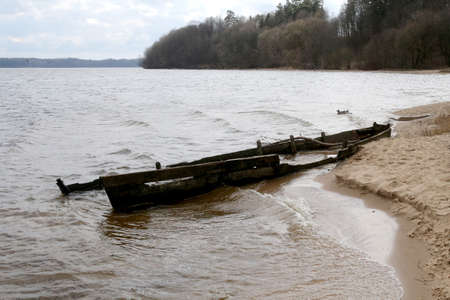 Broken wooden boat on the shore of the lake. Kaunas, Lithuaniaの写真素材