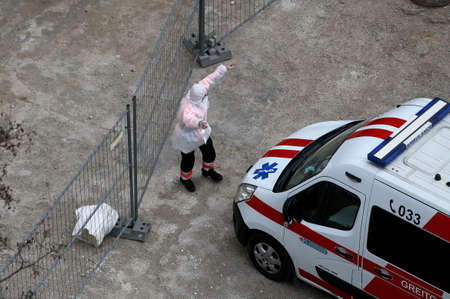 An ambulance and medical staff provide first aid during a pandemic. Lithuania, Kaunasのeditorial素材