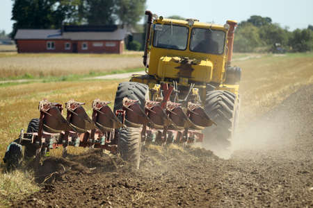 Tractor plowing the stubble field. Lithuania