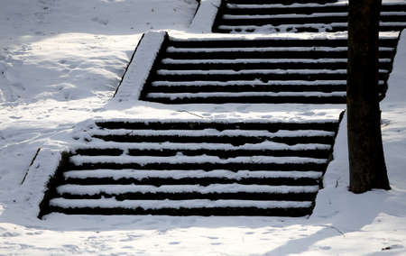 The stairs are covered with snow. Neatly. The problem of snow removal in the city. Not cleanedのeditorial素材