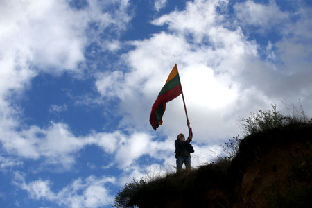 Young happy woman with Lithuanian flag, sky backgroundの写真素材