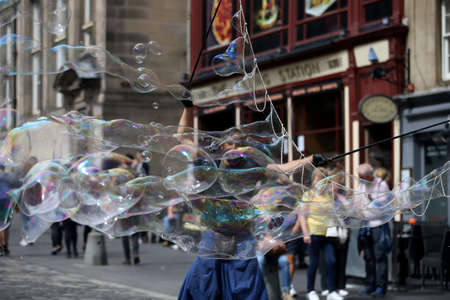 A street artist blows hundreds of small, small and large bubbles in the city center. Edinburgh in Scotland 19 07 2019のeditorial素材