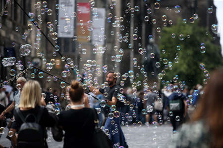 A street artist blows hundreds of small, small and large bubbles in the city center. Edinburgh in Scotland 19 07 2019のeditorial素材