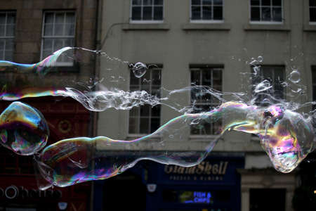 A street artist blows hundreds of small, small and large bubbles in the city center. Edinburgh in Scotland 19 07 2019のeditorial素材