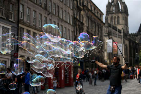 A street artist blows hundreds of small, small and large bubbles in the city center. Edinburgh in...