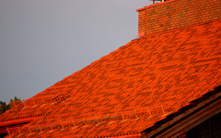 Brightly lit red tiles roof for backgroundの写真素材