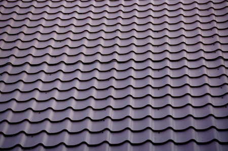 Brightly lit red tiles roof for backgroundの写真素材