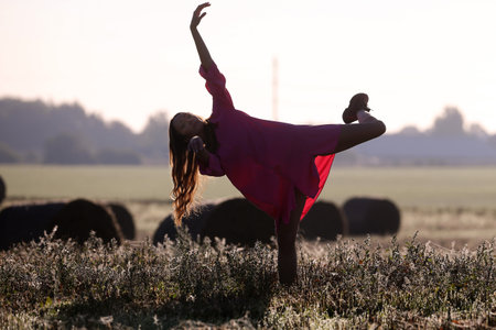 A beautiful girl dances in the fields with pink lingerieの写真素材