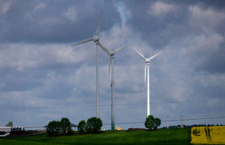 Wind turbine against cloudy blue sky background