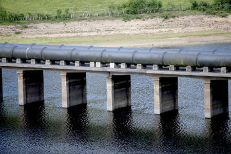 Water pipes across a river in the Derwent Reservoir in the Peak District of Derbyshire.