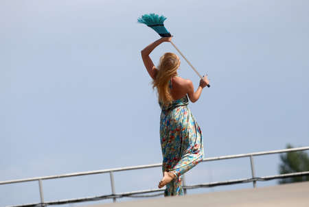 Cute charming beautiful dancer having fun dancing with a broom outside
