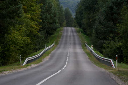 Empty dark rural asphalt highway perspective with white lineの写真素材