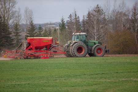 Tractor with high wheels is making fertilizer on young wheat. The use of finely dispersed spray chemicals. Tractor with a spray device for finely dispersed fertilizer. 04 19 2022のeditorial素材