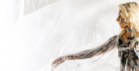 A young woman with a characteristic face is covered with colorful paintの写真素材