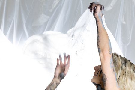 A young woman with a characteristic face is covered with colorful paintの写真素材