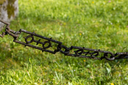 Very old chain to a fence in a cemeteryの写真素材