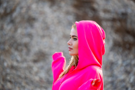 Portrait of a fashionable blonde girl in a ping colored hoodieの写真素材