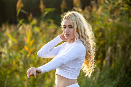 Blonde model with long hair posing in natureの写真素材