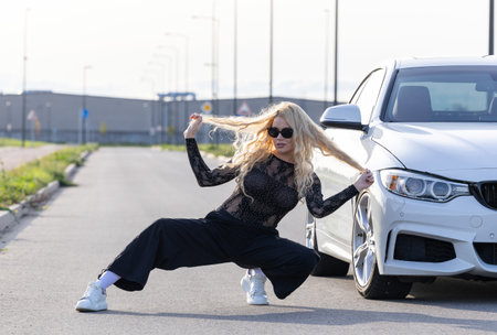 Black-clad blonde with sunglasses poses in hip-hop styleの写真素材
