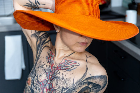 Social photography, portrait of a tattooed girl with a hat at homeの写真素材