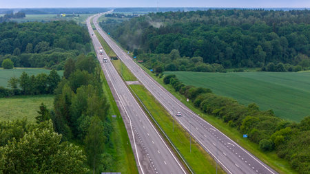 Cars movement on a highway, aerial view. Car traffic on a suburban highway in summer day. Logistic...