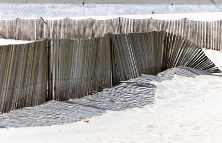 The shadow thrown by a fence on the beachの写真素材