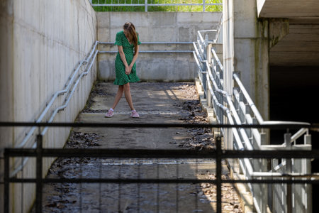 A young girl in a green dress. Youthful beauty in a desolate landscapeの写真素材