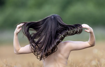Portrait of a beautiful young girl with hair blowing in the windの写真素材
