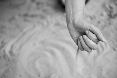 Time Slipping Through Fingers in Grains of Sand. A Moment Slipping Along with Streams of Sandの写真素材