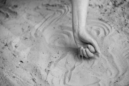Time Slipping Through Fingers in Grains of Sand. A Moment Slipping Along with Streams of Sandの写真素材