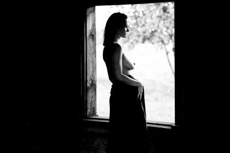 Young woman enjoying summer time outdoors in hot sunny day. Brunette posing near unfinished country houseの写真素材