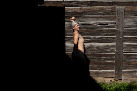 Female figure, back and shadow in the background of a found village houseの写真素材
