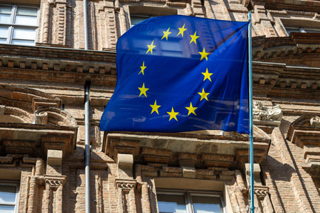 European Union flag waving above the city, blue with a yellow starの写真素材