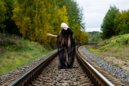 Female figure from behind, draped in tulle, on railway tracks, halloween themeの写真素材