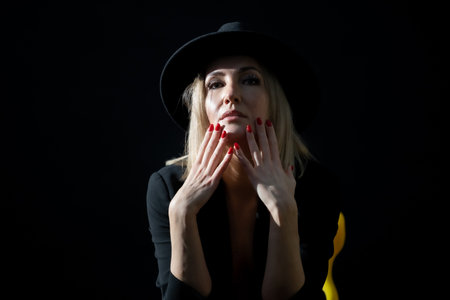 Hat and Light: A Portrait of a Beautiful, Mature Woman in the Studioの写真素材