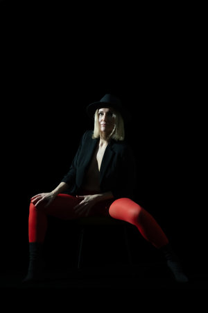 A beautiful blonde woman posing in the studio with red stockings: The Play of Red Eleganceの写真素材